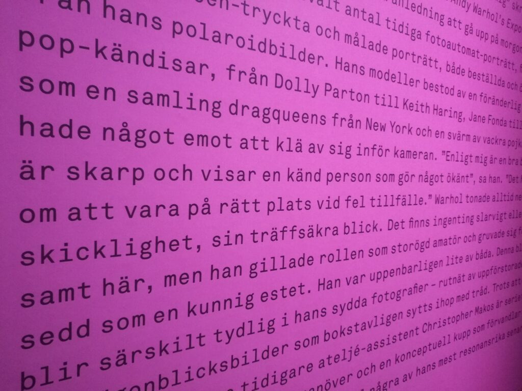 Svart text på rosa botten om Andy Warhol