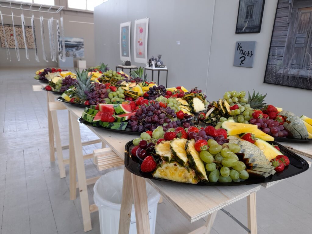 Bord med fruktfat, i bakgrunden konst.